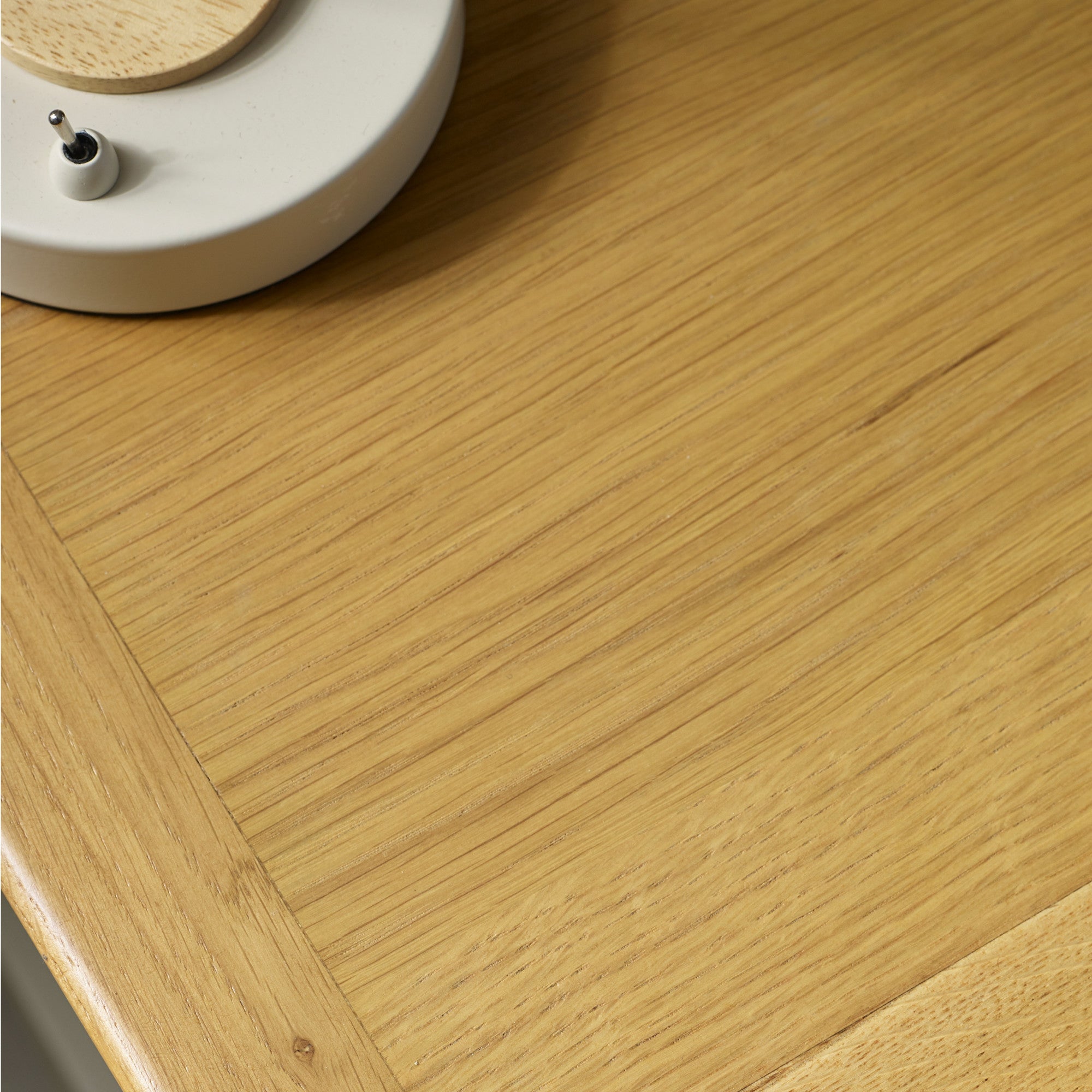 Close-up of natural wood grain on bedside table top, emphasizing fine vertical and diagonal wood lines