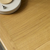 Close-up of natural wood grain on bedside table top, emphasizing fine vertical and diagonal wood lines