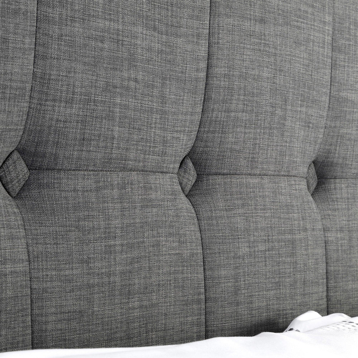 Close-up of slate linen bed headboard with stitched panel detail