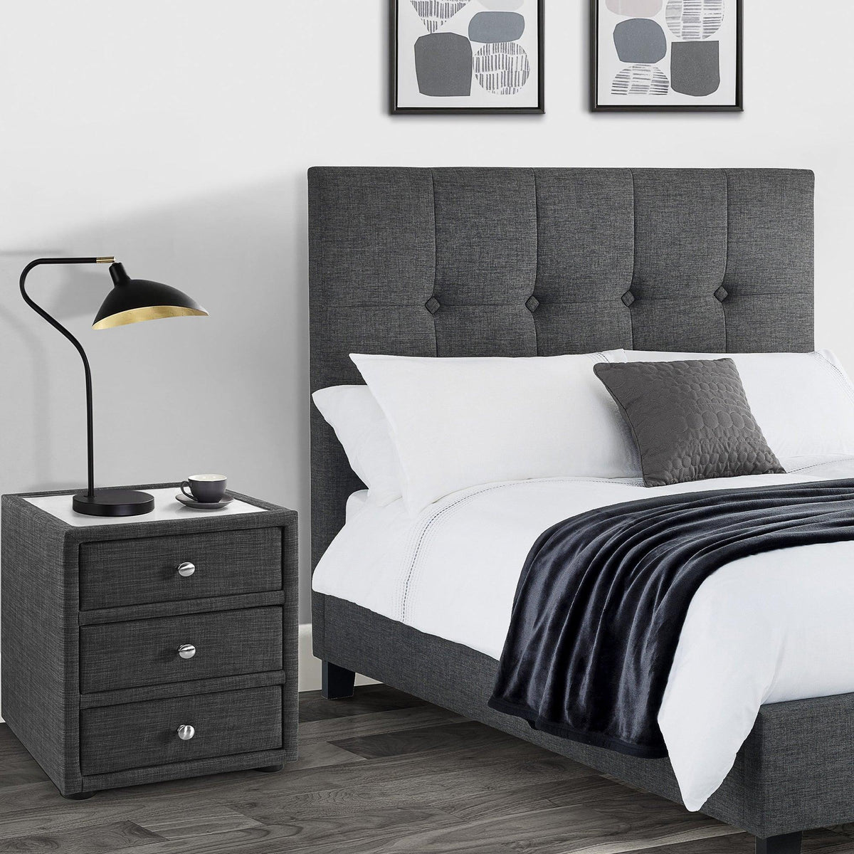 Slate linen three drawer bedside table next to upholstered bed in modern bedroom