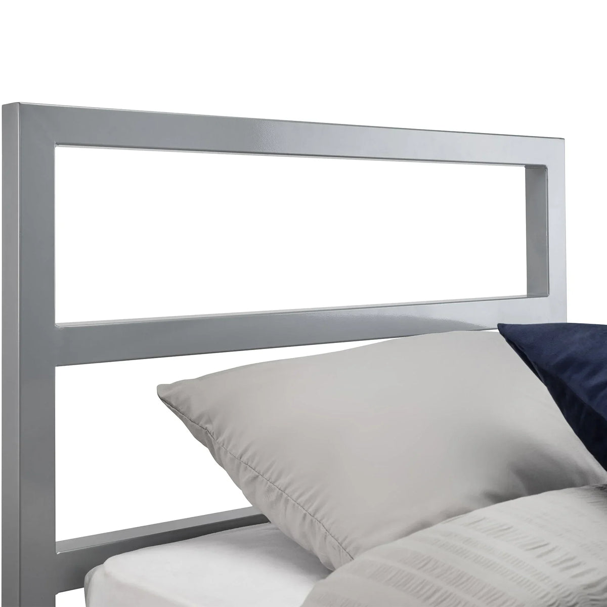 Silver metal bed frame headboard detail with grey pillow and bedding