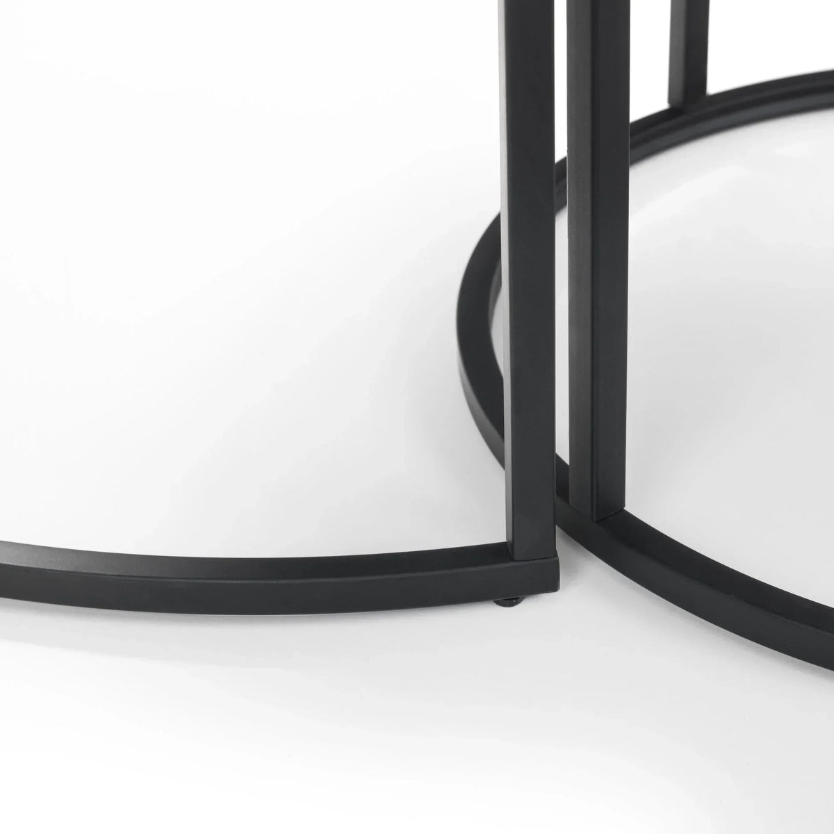 Black metal base detail of round nesting coffee tables on white background