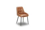 A modern dining chair upholstered in warm tan leather with a tufted backrest and slim black metal legs, shown on a plain white background.