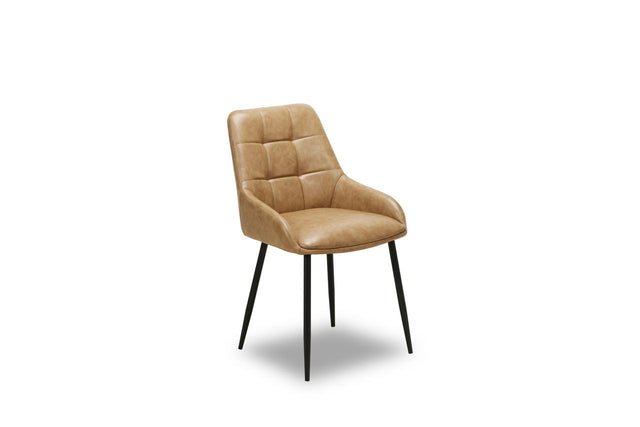 A modern dining chair with a tan quilted faux leather upholstered seat and back, supported by slim black metal legs, shown against a plain white background.