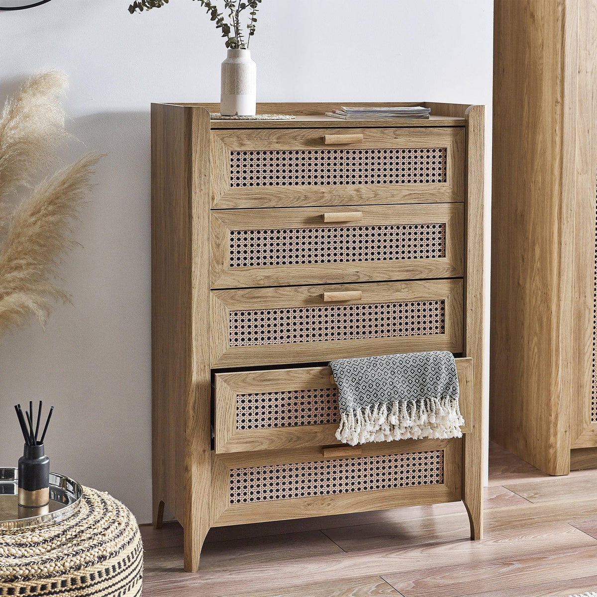 Sydney rattan effect 5 drawer chest with open drawer and decorative vase in modern room