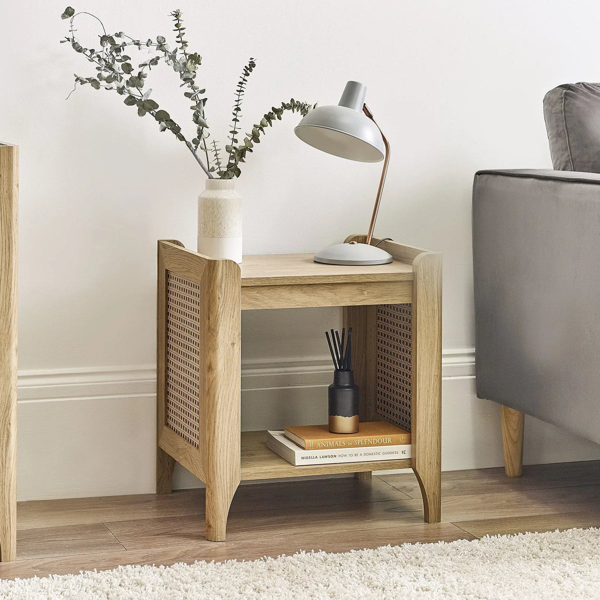 Sydney rattan effect lamp table with removable shelf beside grey sofa in living room