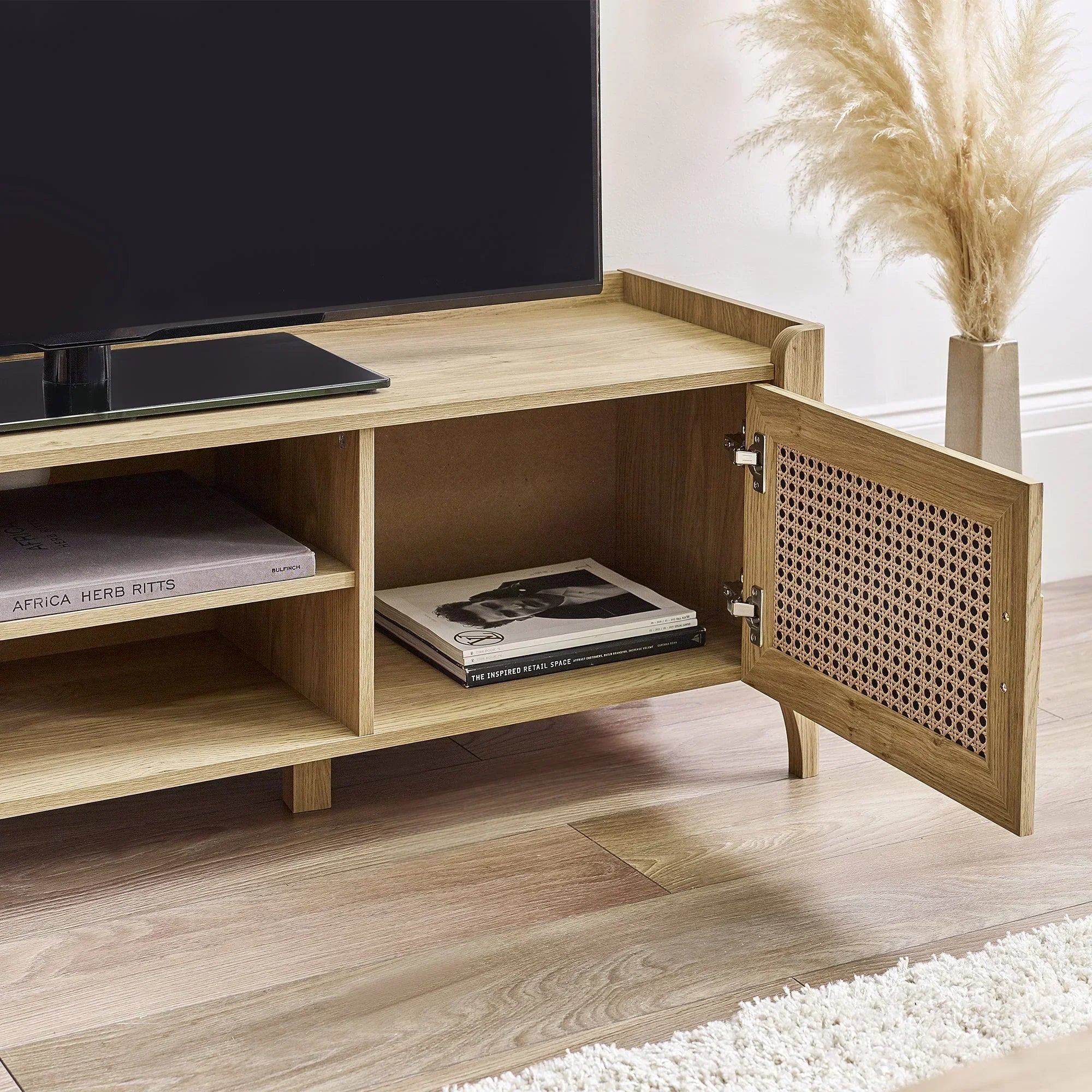 Rattan effect media unit in light wood with open storage door and visible shelving detail