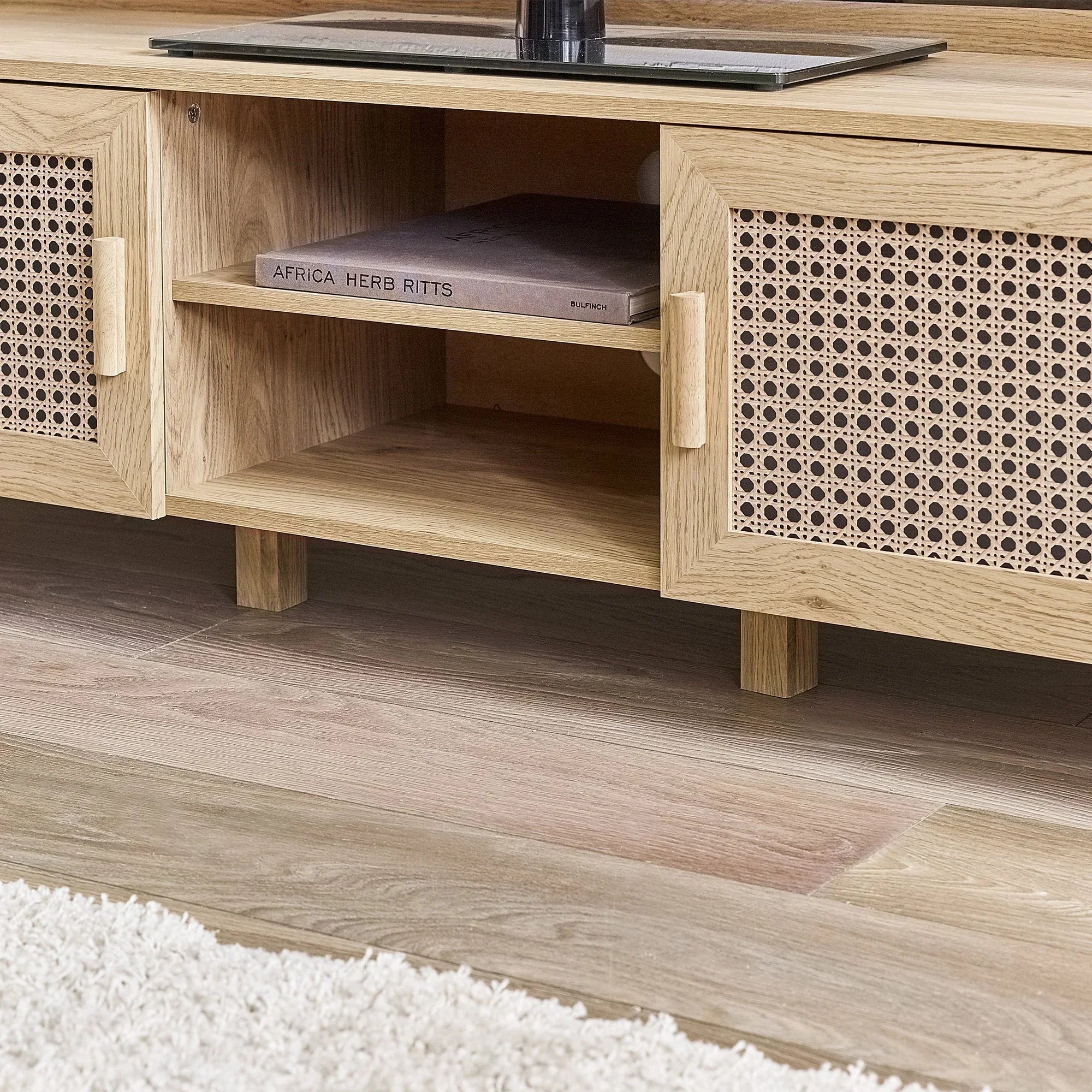Rattan effect media unit with wooden finish and open shelf detail on wood flooring