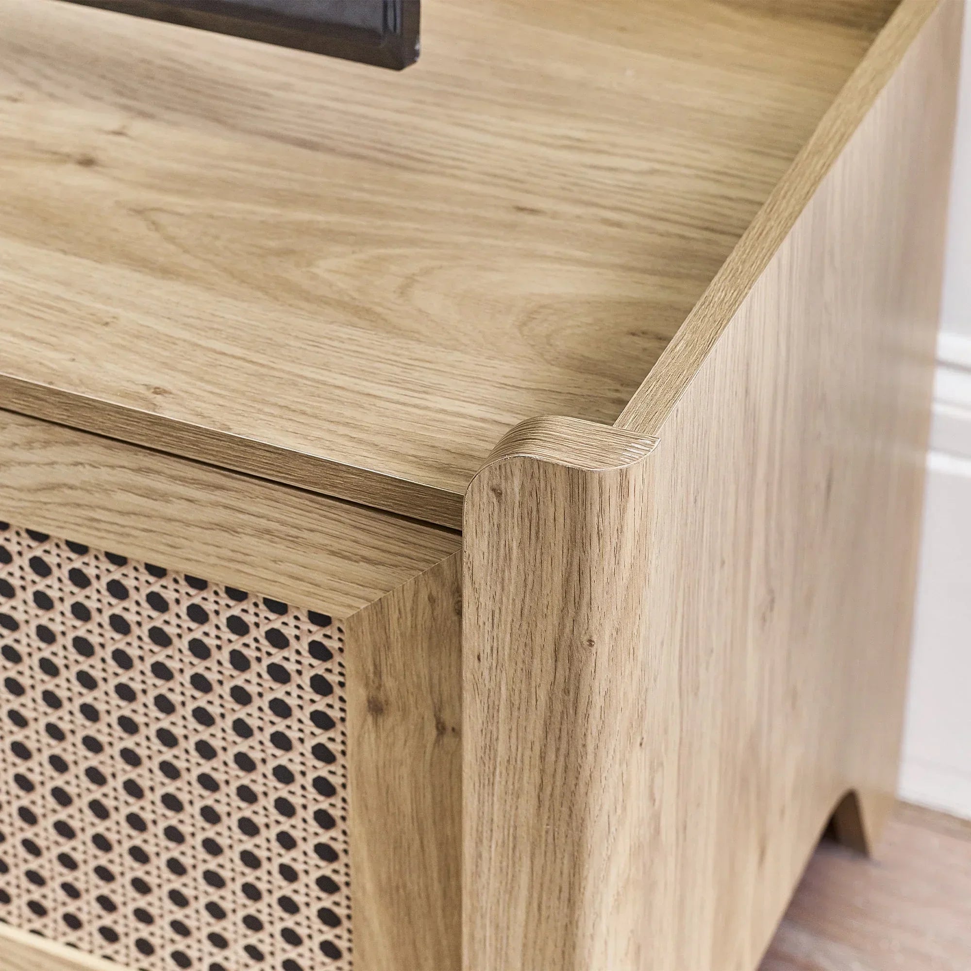 Close detail of rattan effect media unit with light wood finish and woven panel design