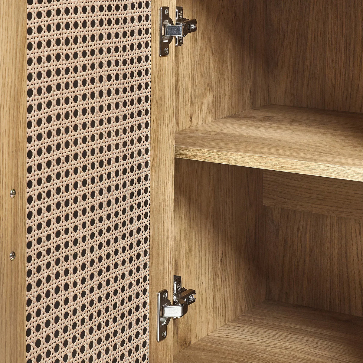 Rattan effect sideboard door open showing wood grain shelves and interior hinge detail