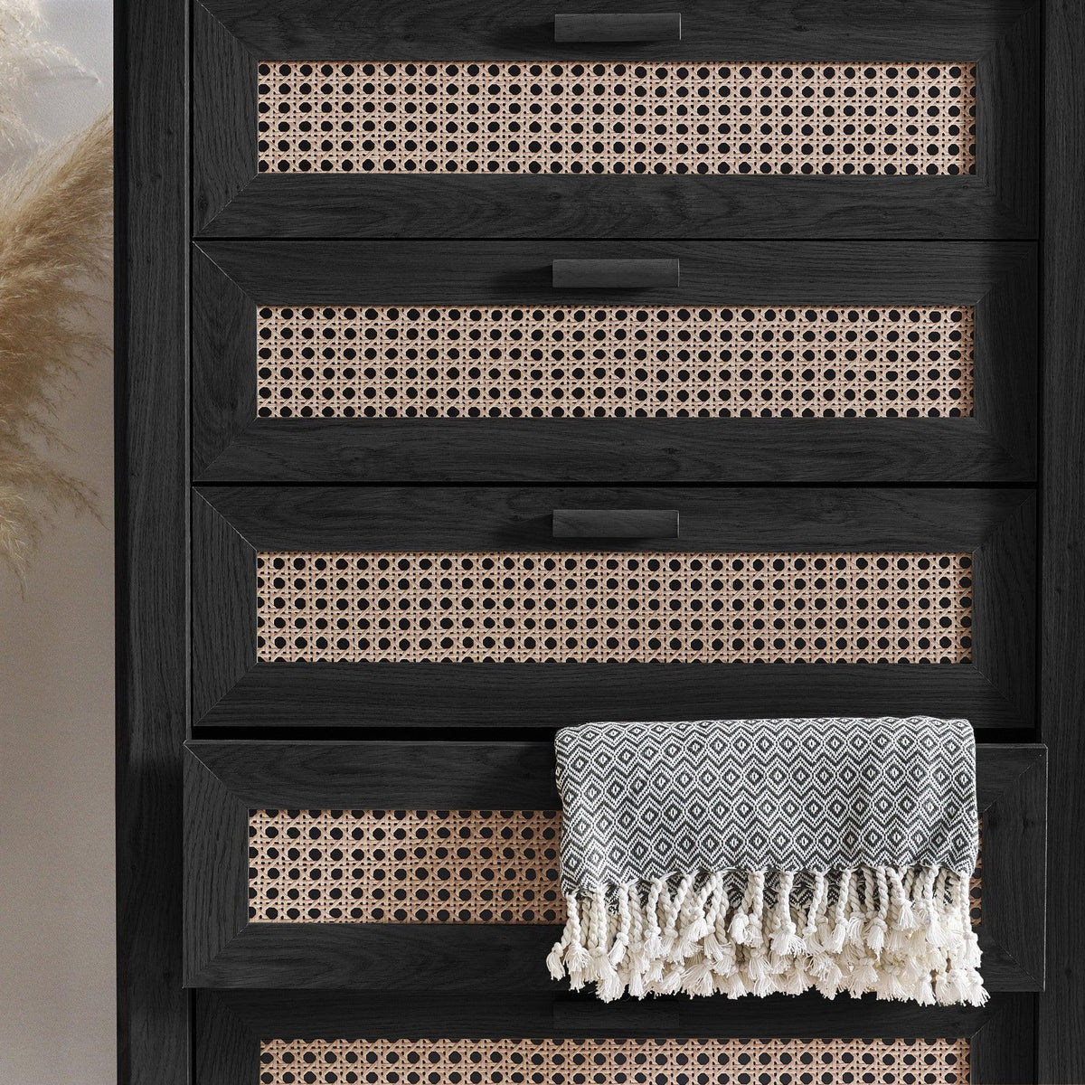 Sydney black ash rattan effect 5 drawer chest with patterned throw draped on drawer