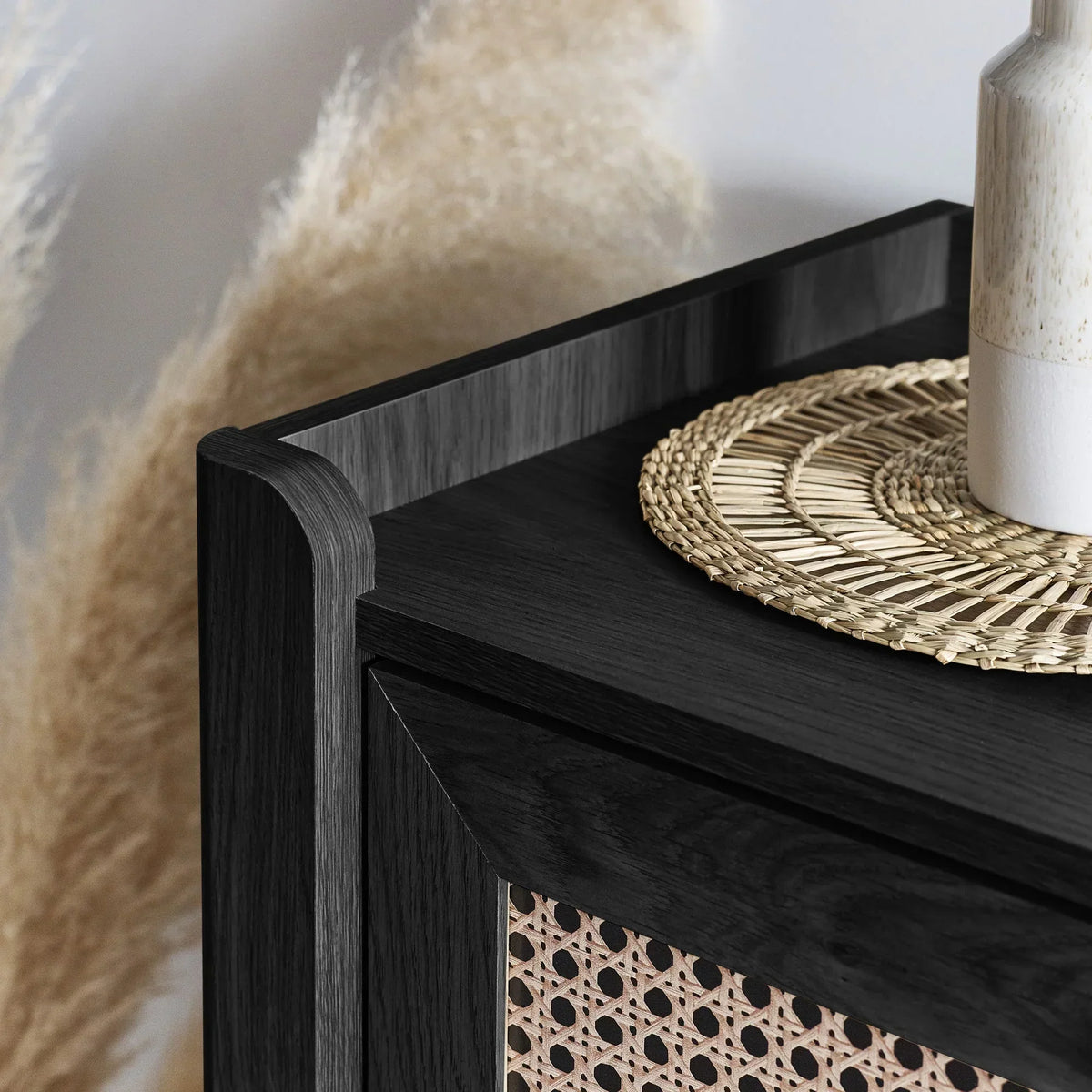 Sydney rattan effect black ash chest corner with woven detail and ceramic vase on top