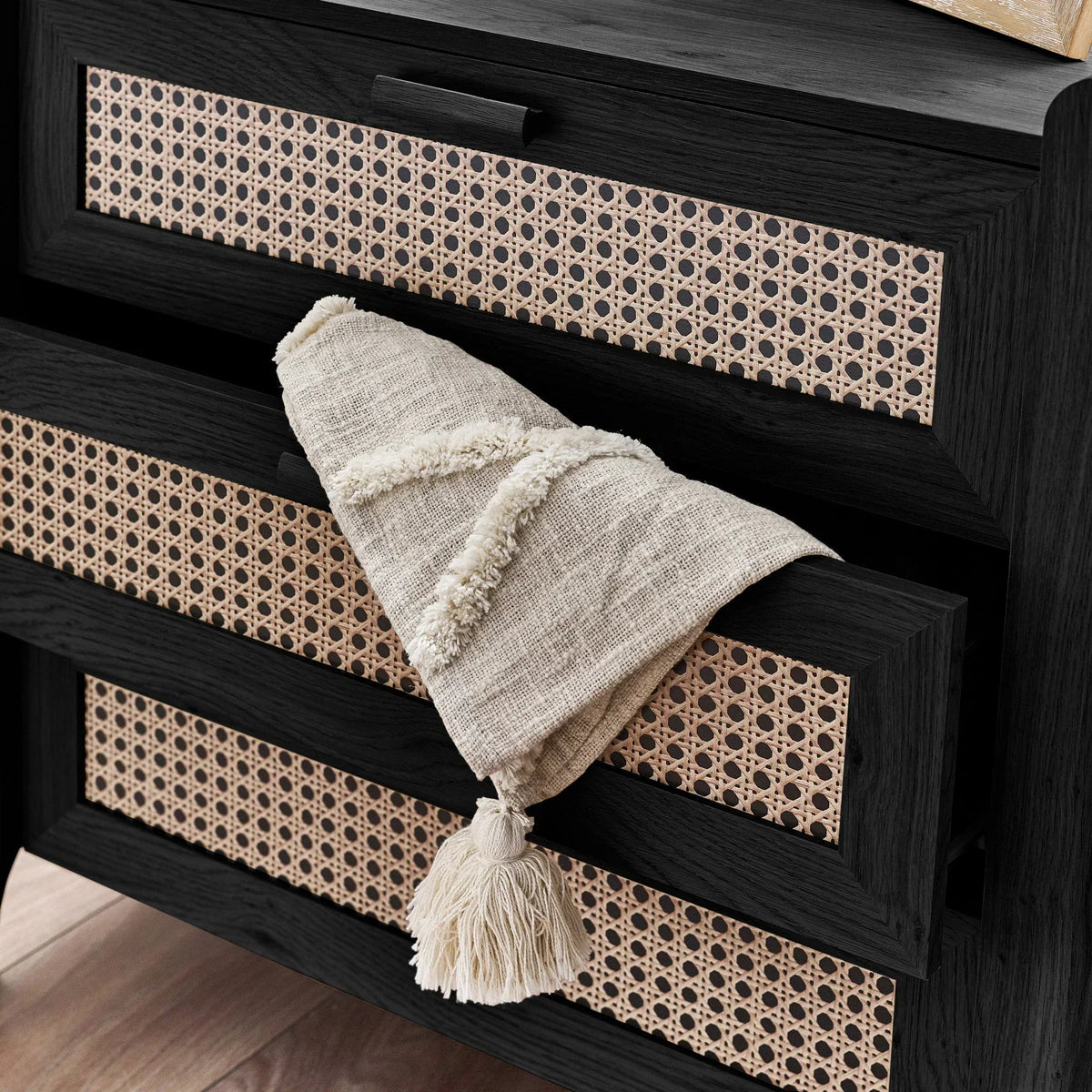 Black ash rattan effect three drawer chest close-up with open drawer and textured throw