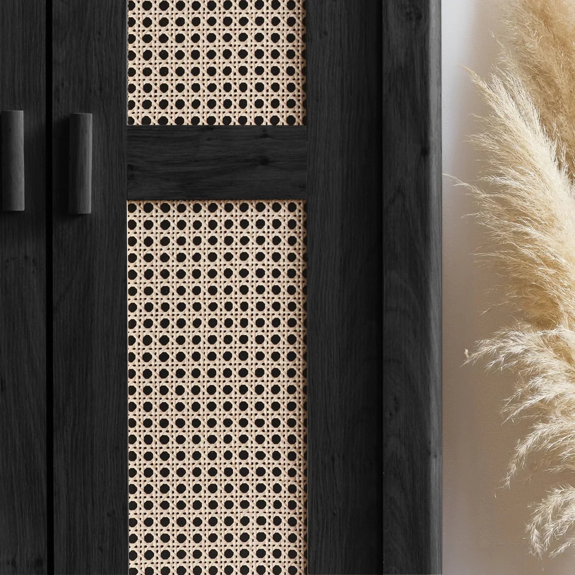 Close-up of black rattan effect wardrobe doors with woven panel and pampas grass decor