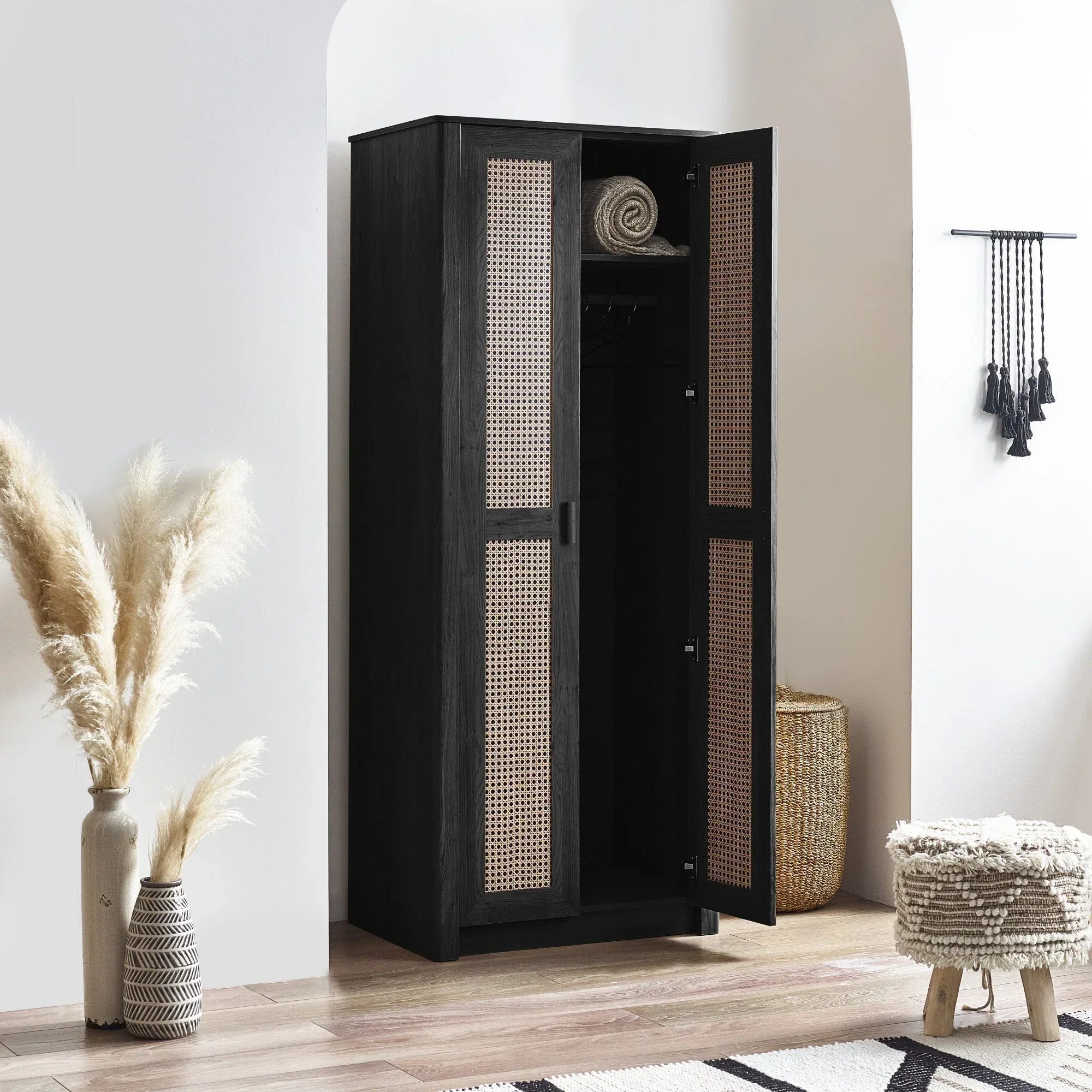 Black rattan effect two door wardrobe with open doors in modern bedroom setting
