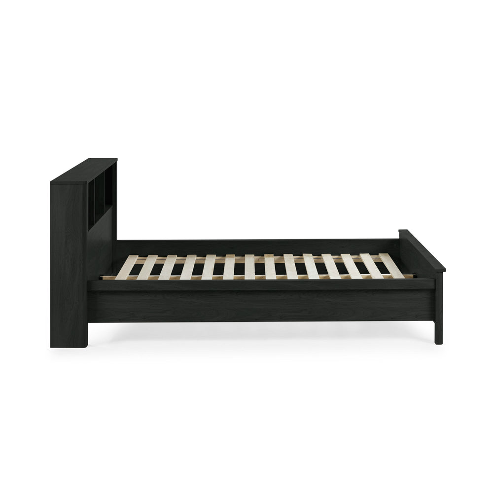 Side view of black double bed with rattan inset storage shelves in headboard, no mattress on white background