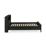 Side view of black double bed with rattan inset storage shelves in headboard, no mattress on white background