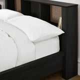 Close-up of black double bed's headboard showing rattan inserts and white bedding with grey throw