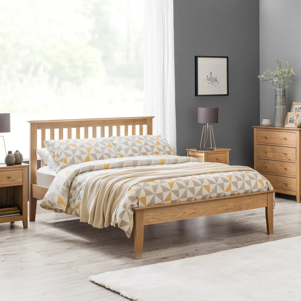 Oak bed frame with slatted headboard in modern bedroom, matching oak bedside tables and drawers