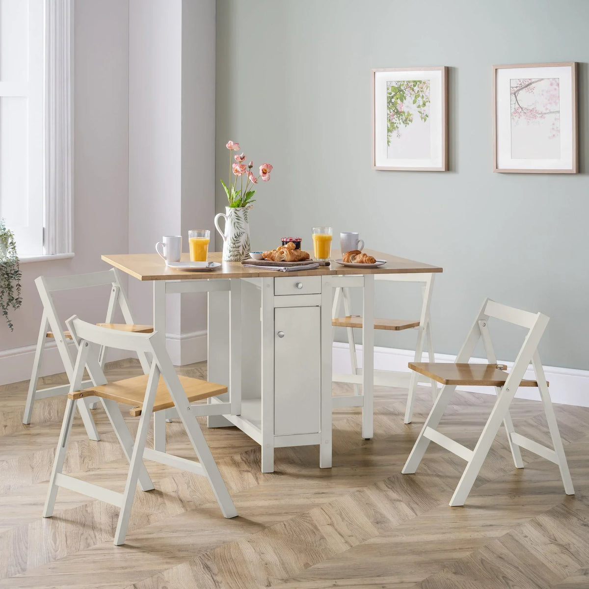 White and natural wood dining set with four folding chairs in a bright dining room