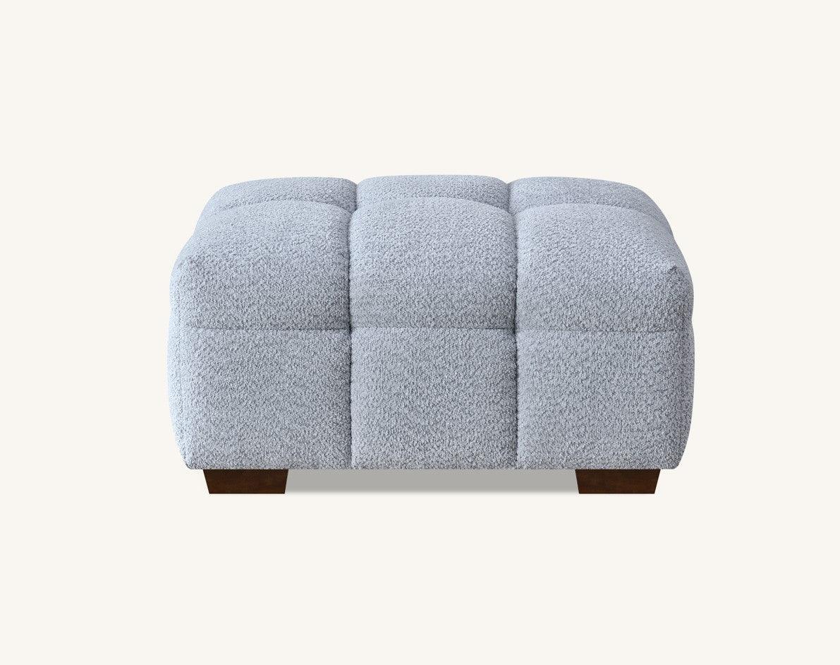 Light grey upholstered ottoman with textured fabric and wooden legs, front view
