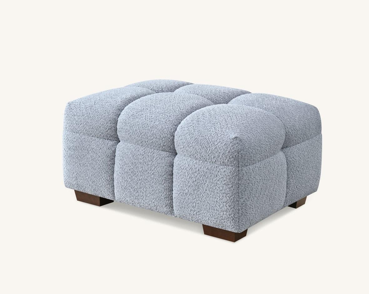Light grey boucle ottoman with tufted cushion design and wooden legs
