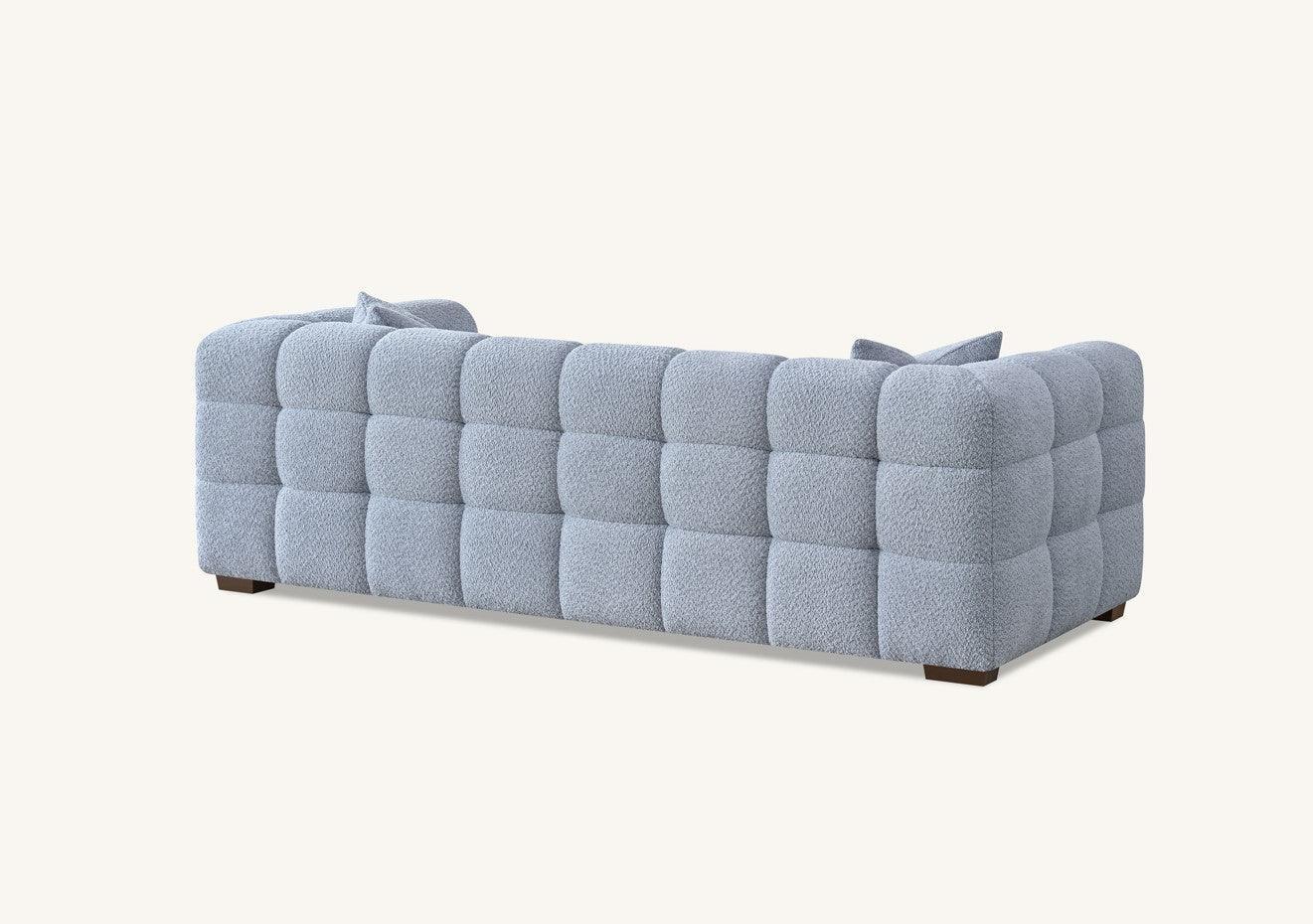 Textured grey sofa with grid pattern upholstery and low wooden legs, rear angle view