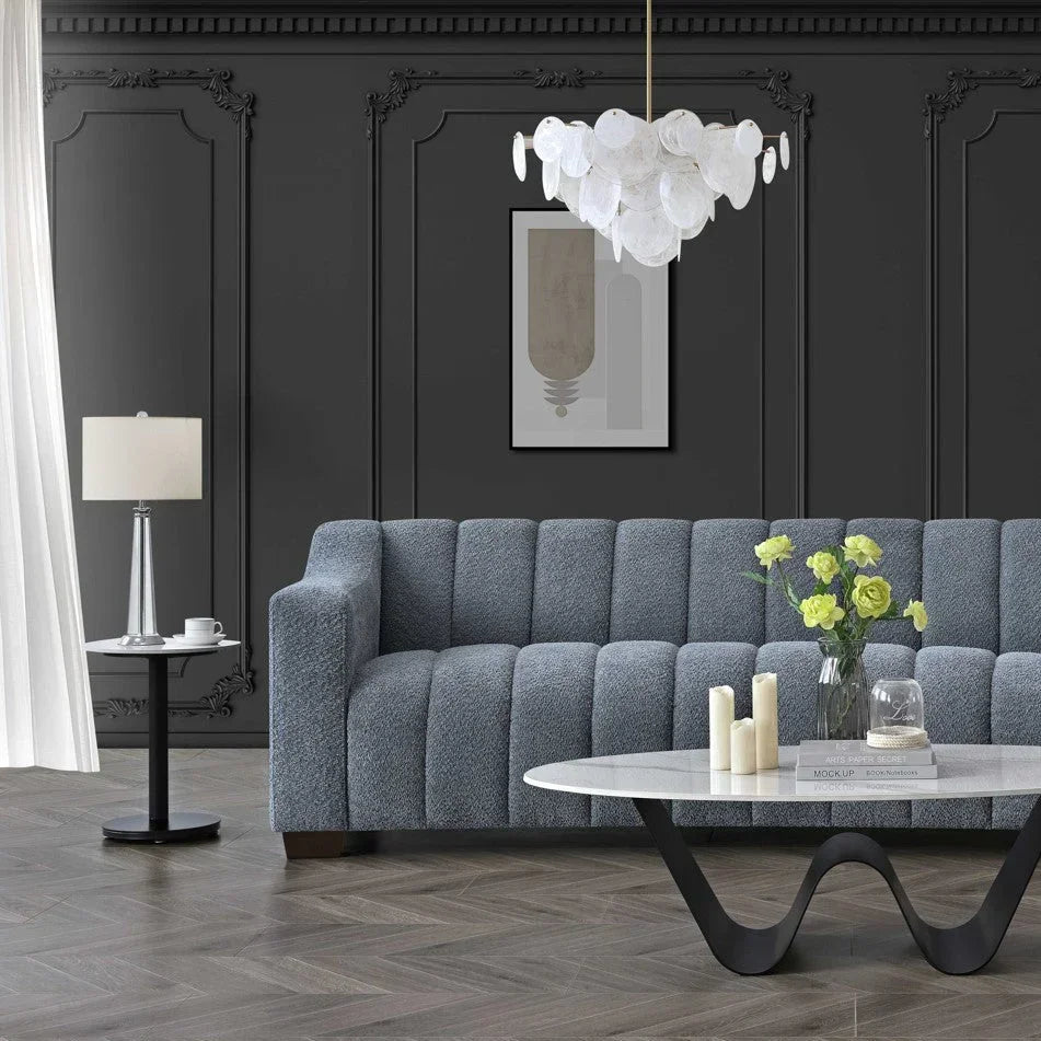 Grey textured sofa with vertical channels, marble coffee table, black panel wall, modern decor