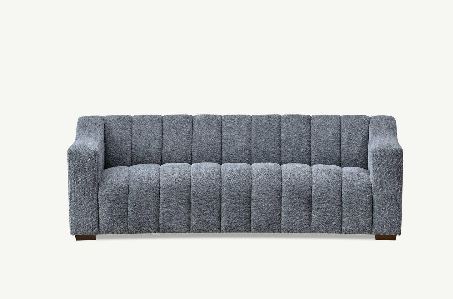 Grey fabric sofa with deep channel tufting and square arms, front view on white background