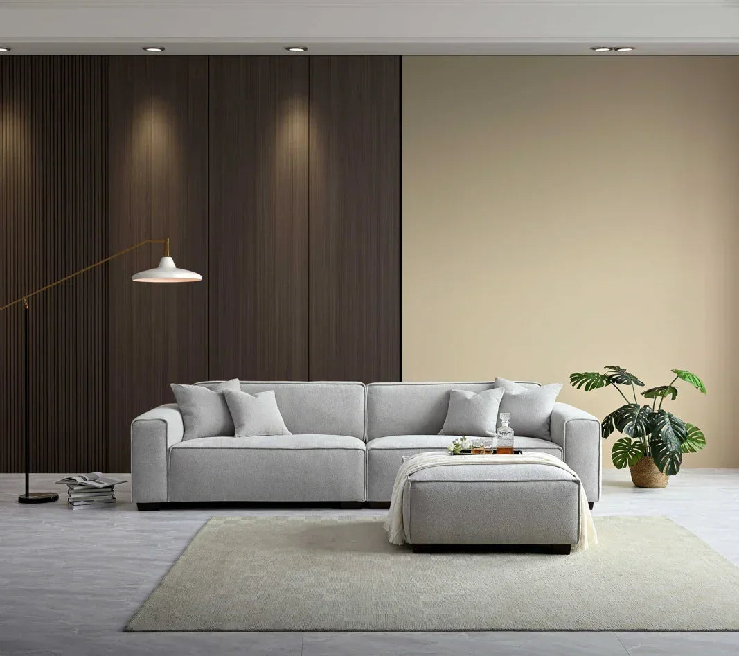 Light grey corner sofa set with ottoman on beige rug in modern living room