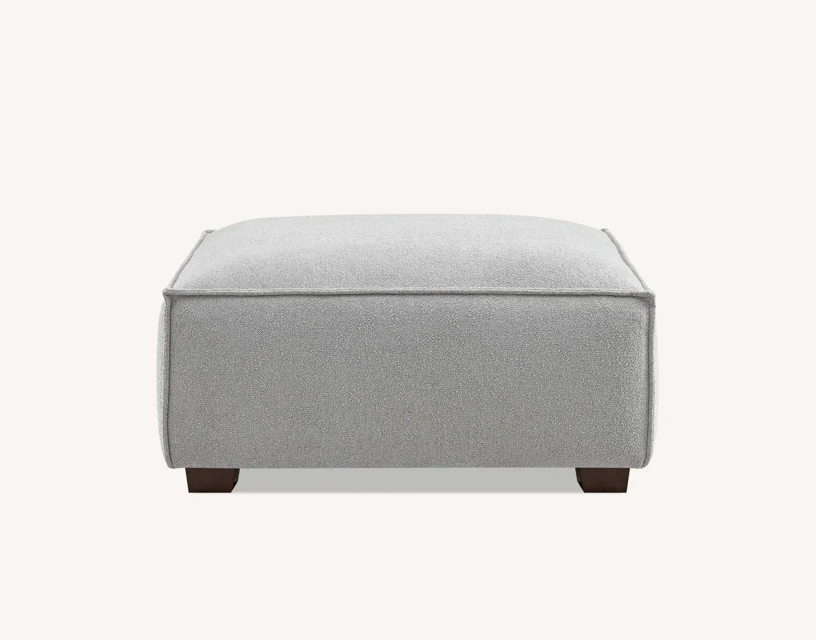 Light grey fabric ottoman with square shape and low wooden legs