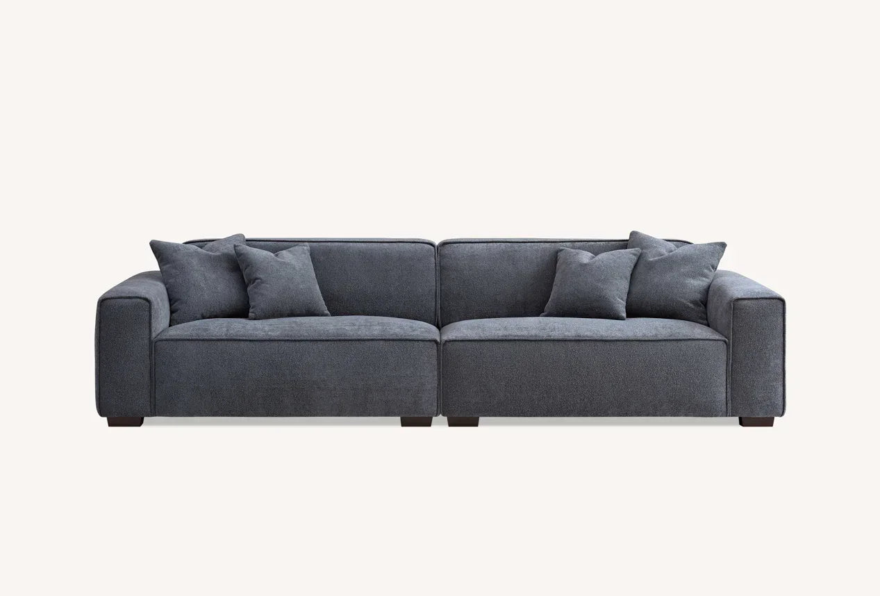 Dark grey fabric sofa with wide arms and matching scatter cushions front view