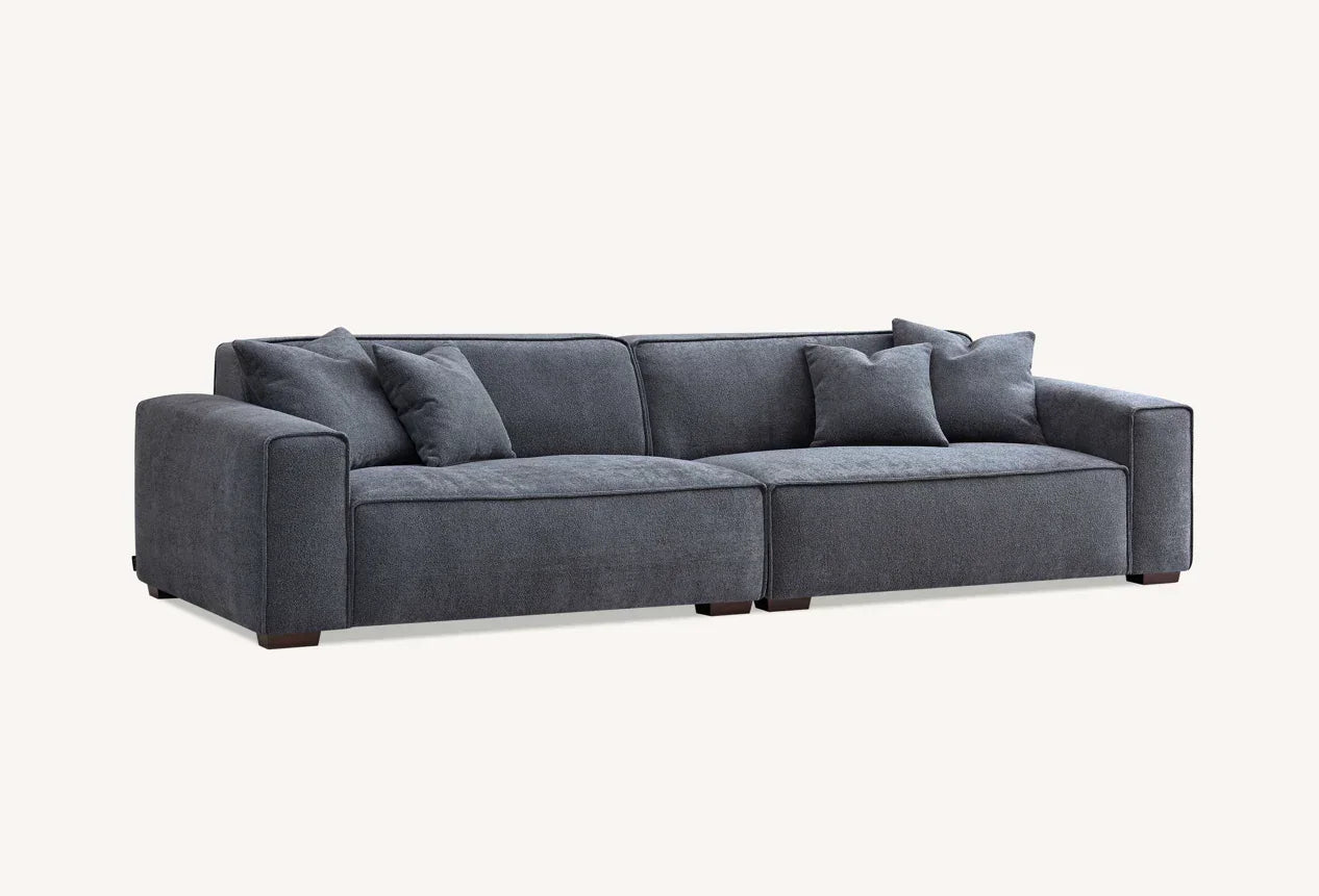 Dark grey fabric sofa with wide arms and matching scatter cushions, front angled view