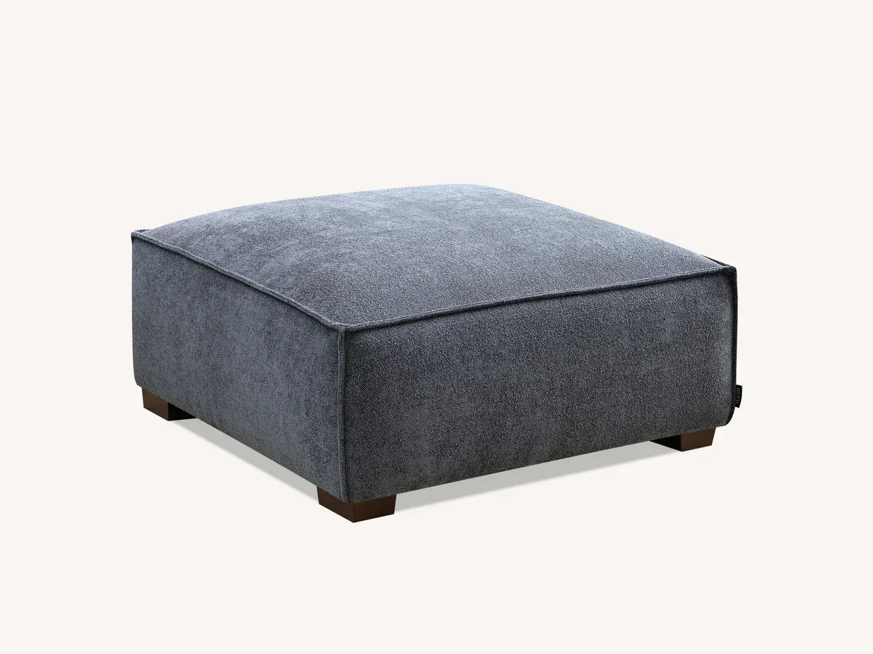 Grey fabric ottoman footstool with wooden legs, square design, angled view