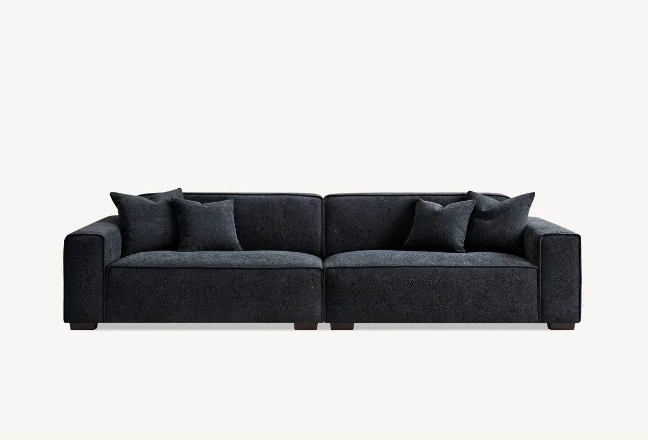 Dark grey fabric sofa with wide arms and four matching scatter cushions, front view