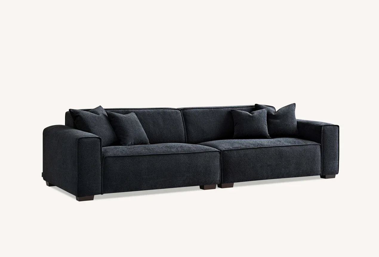 Dark fabric sofa with wide armrests and scatter cushions, modern living room furniture