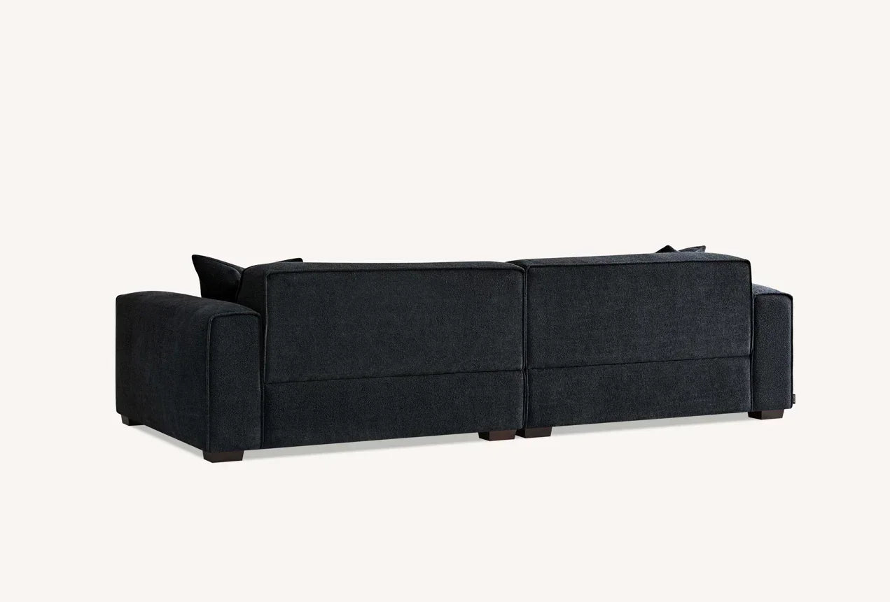 Rear view of dark fabric corner sofa with wide armrests and clean lines