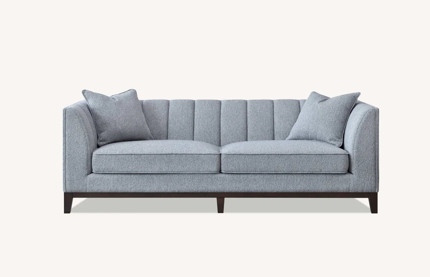 Grey fabric sofa with channel-tufted back, two seat cushions and two matching throw pillows