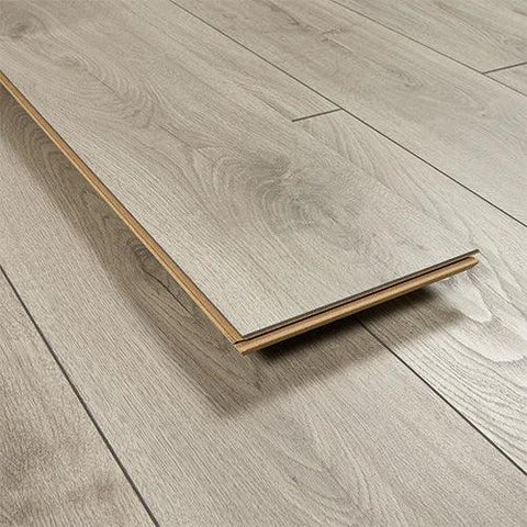 Silver oak wood flooring plank on matching laminate floor, showcasing grain and texture