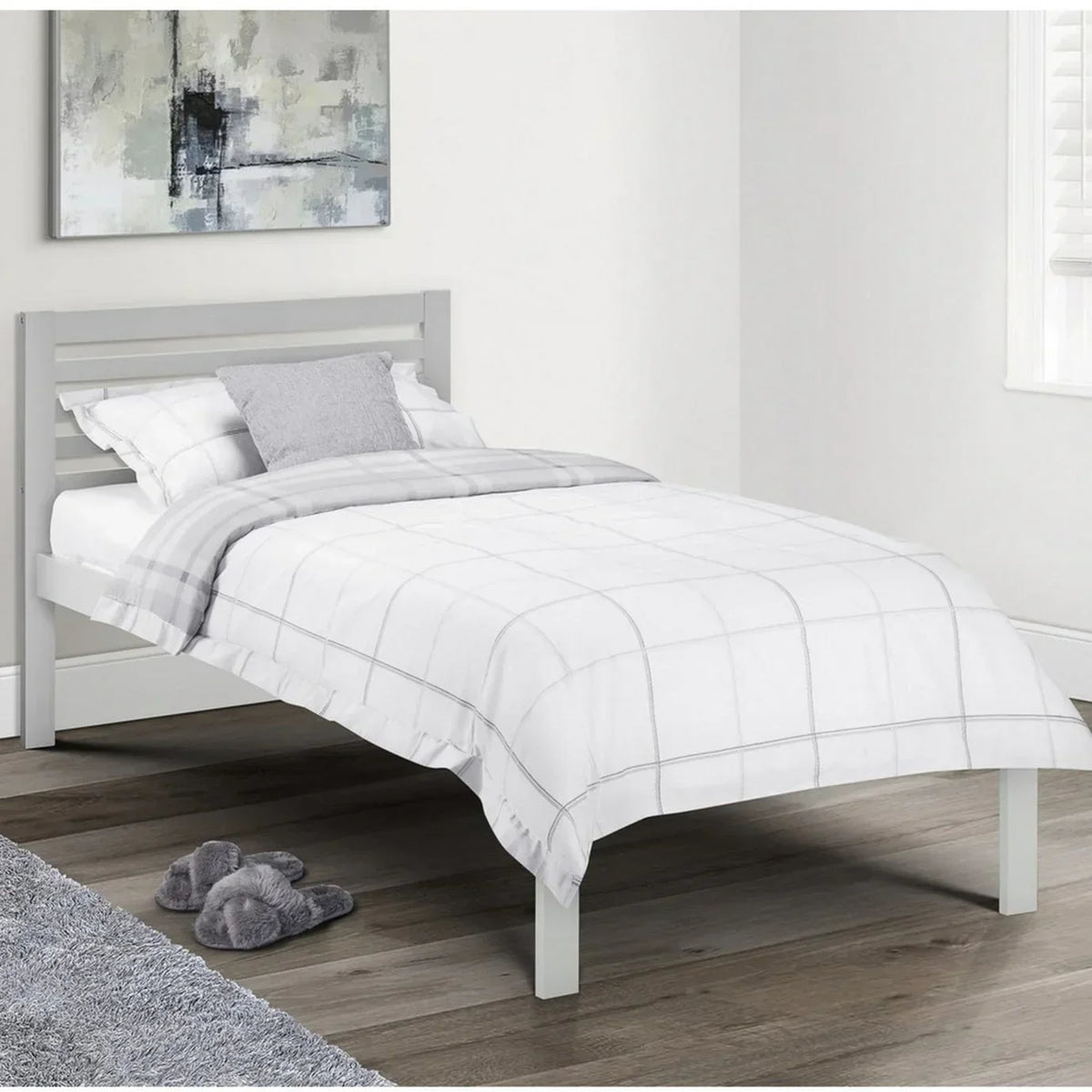 Grey single bed frame with white check bedding in bright modern bedroom