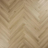 Light oak herringbone flooring with natural wood grain texture and chevron pattern