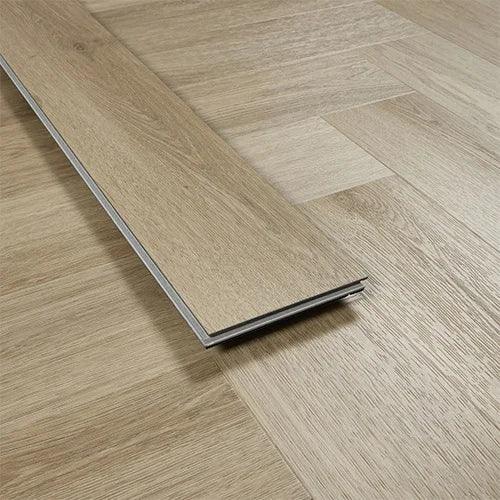 smokey oak laminate flooring plank on light wood herringbone floor close-up