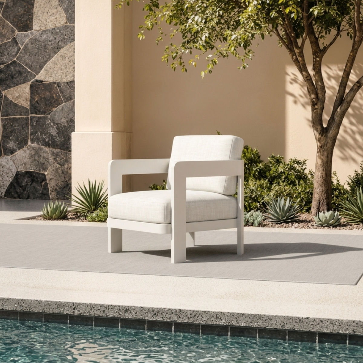 White cushioned armchair with smooth frame on outdoor patio near pool and plants
