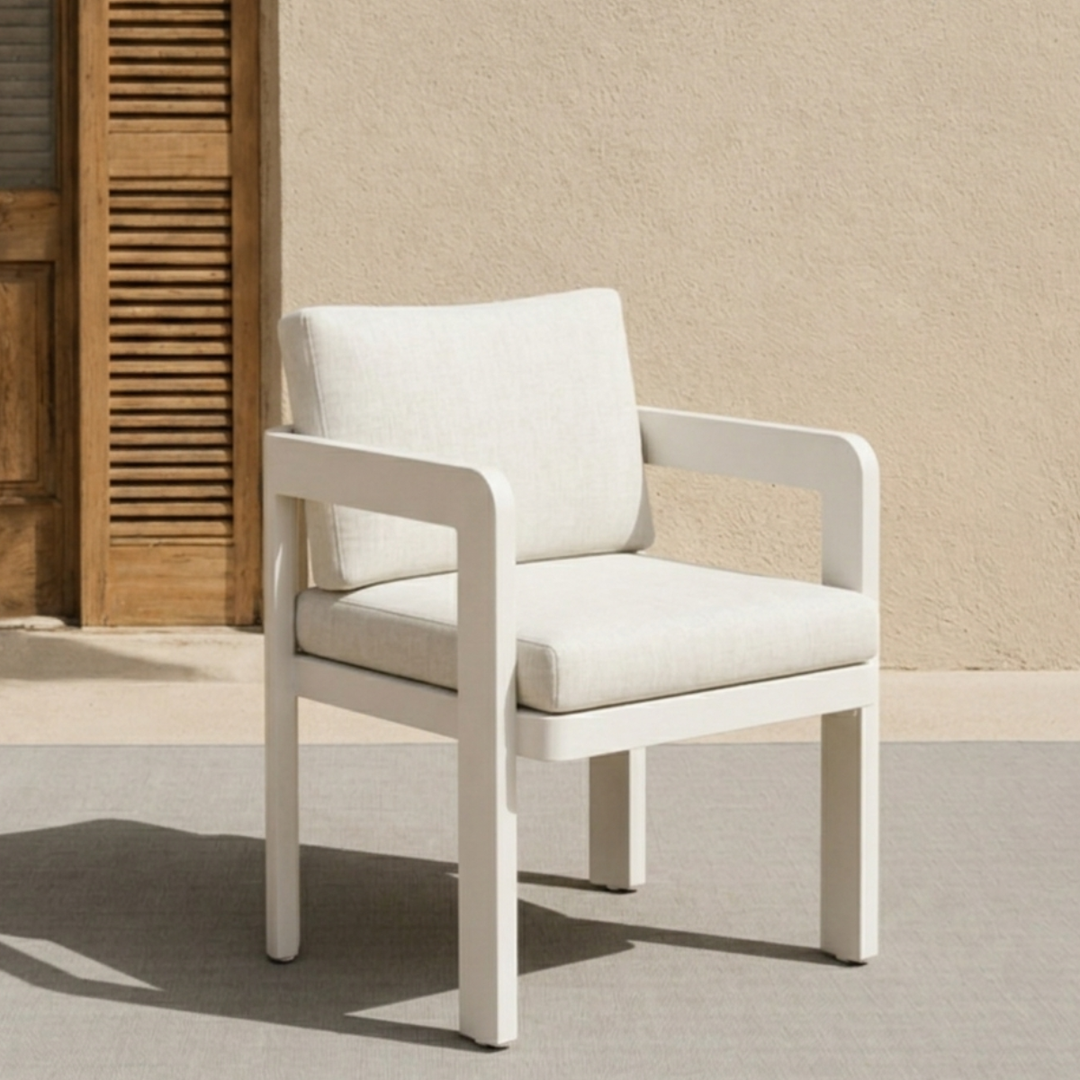 White painted metal frame chair with cream fabric cushions against beige wall