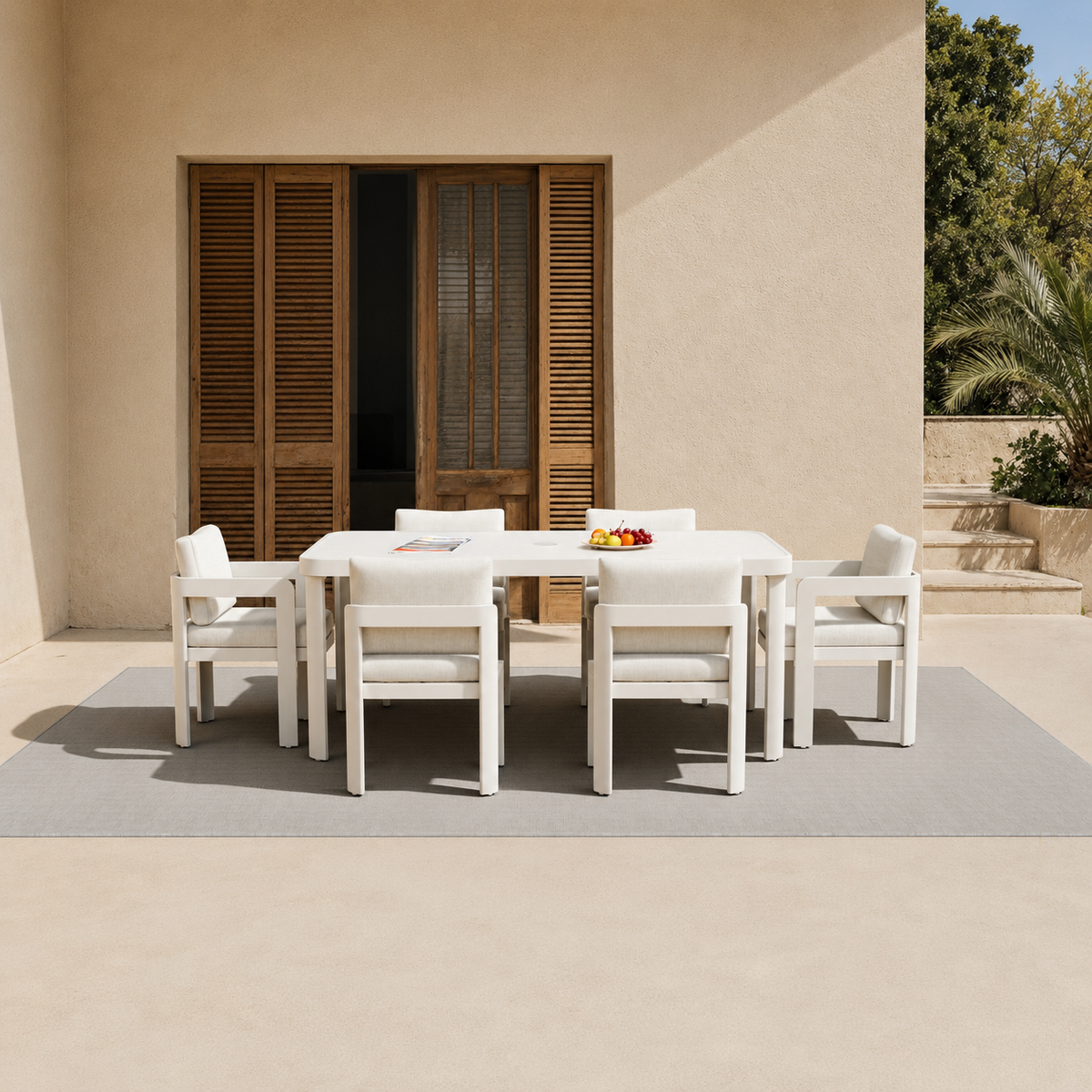 White cushioned outdoor dining set with six chairs and a rectangular table on grey rug | Home Centre