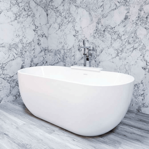 White freestanding bathtub against a marble wall