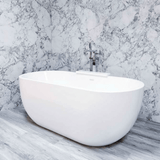 White freestanding bathtub against a marble wall