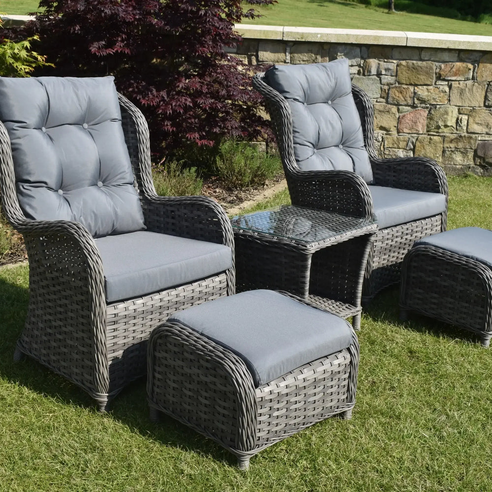 Grey rattan garden bistro set with two cushioned chairs, glass table, and two footstools