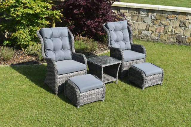 Grey rattan bistro garden set with two armchairs, ottomans and glass top table on lawn