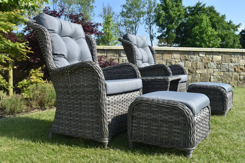 Grey rattan garden bistro set with cushioned chairs and ottomans on grass